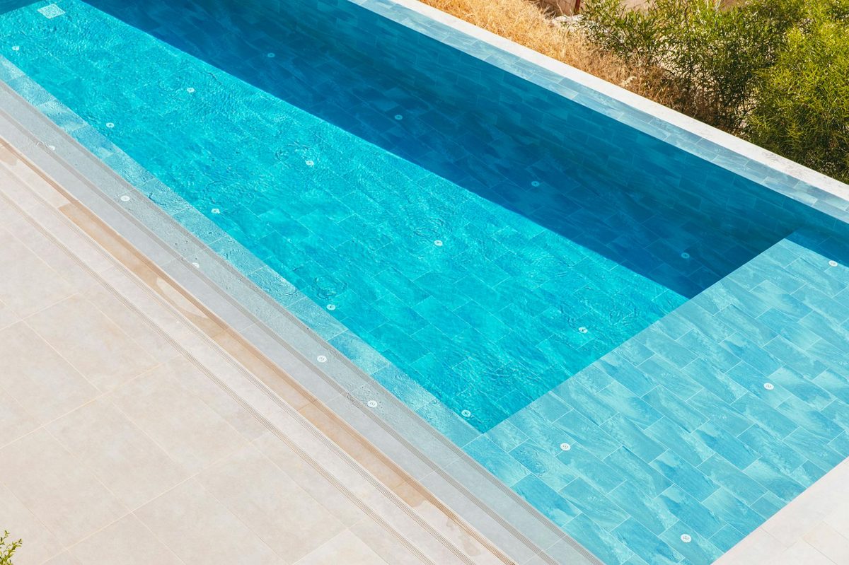 Textured pebble aggregate pool finish with stone coping - pebble pool finish in Cape Coral, FL