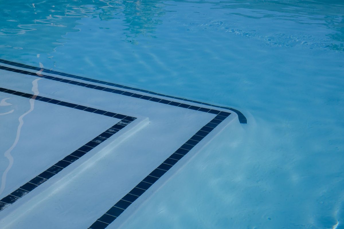 Freshly resurfaced white plaster pool with a tiled step - pool resurfacing cost in Cape Coral, FL