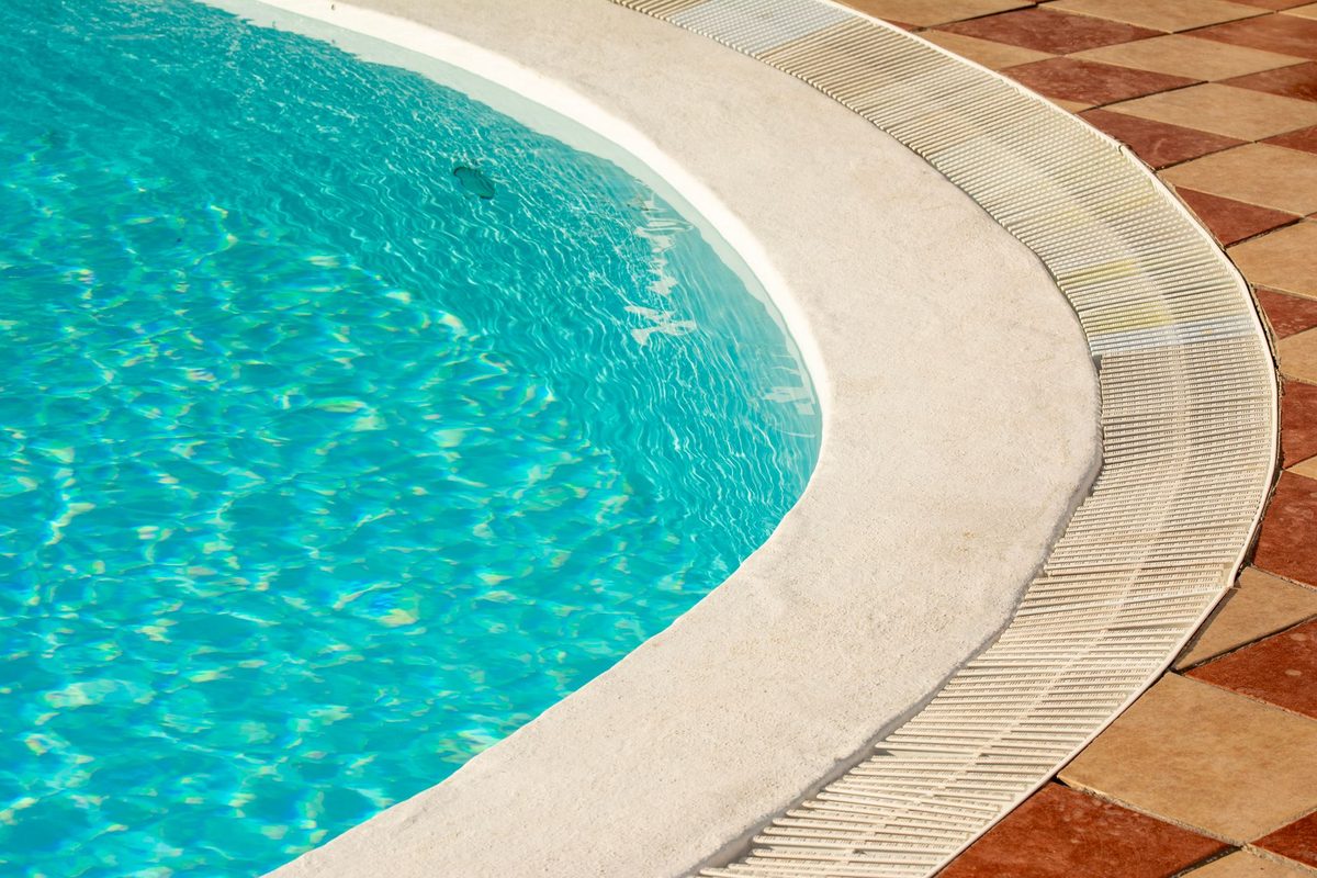 Sunlit pool edge with textured coping and tile deck - Fort Myers Beach, FL pool resurfacing service area